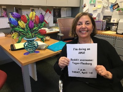 Image of Boston College Professor Helen Tager-Flusberg holding a piece of paper promoting here AMA on Reddit