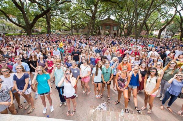 A crowd of students wearing sunglasses preparing to watch eclipse 